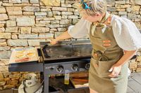 A person cleans the Blackstone 1554 Cooking 4 Burner Flat Top Gas Grill