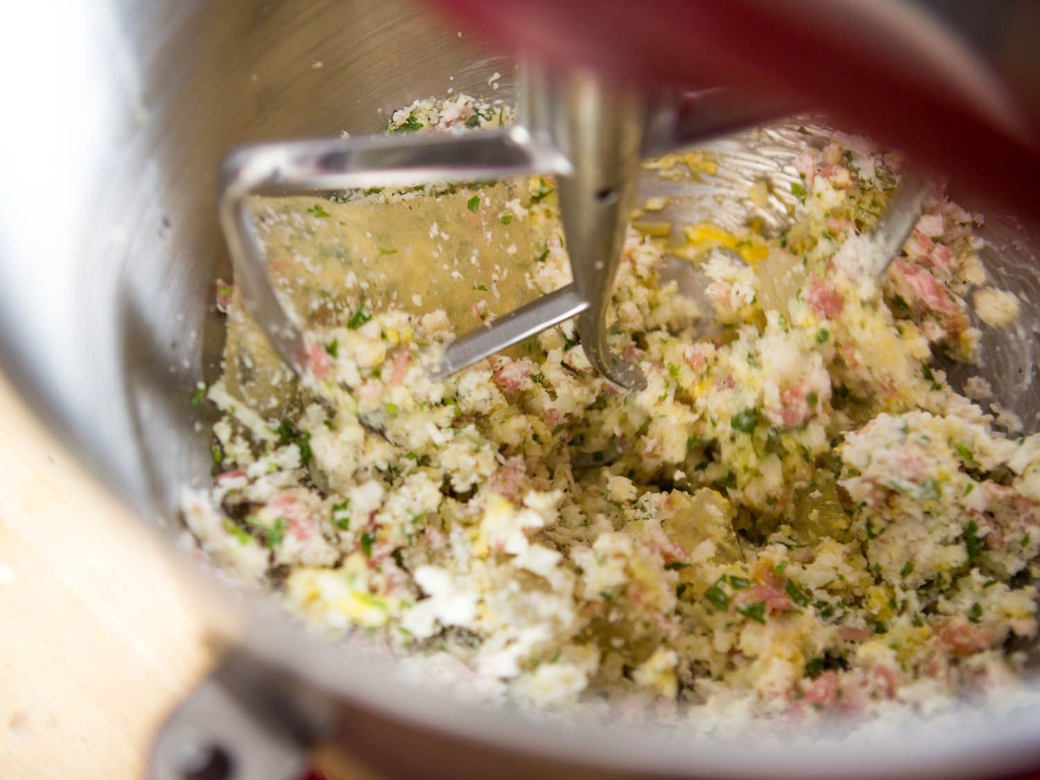 Beating together panade and flavoring ingredients for meatballs.
