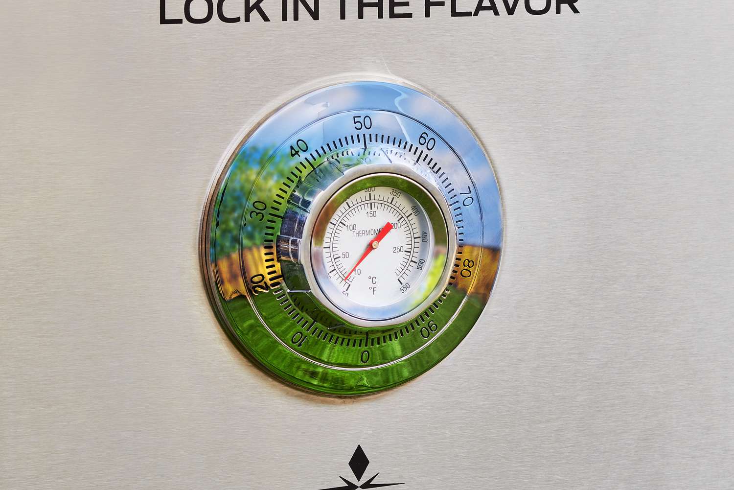 A closeup of the internal temperature gauge of a gas smoker. 