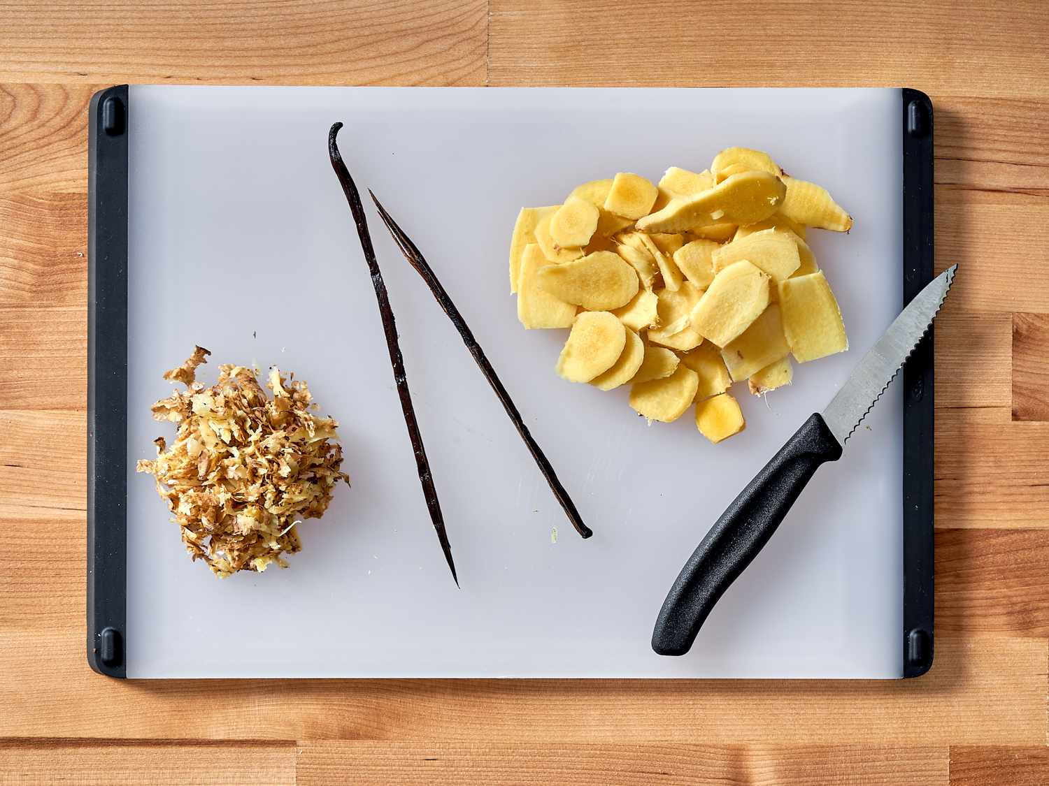 Peeled ginger and vanilla beans on a cutting board