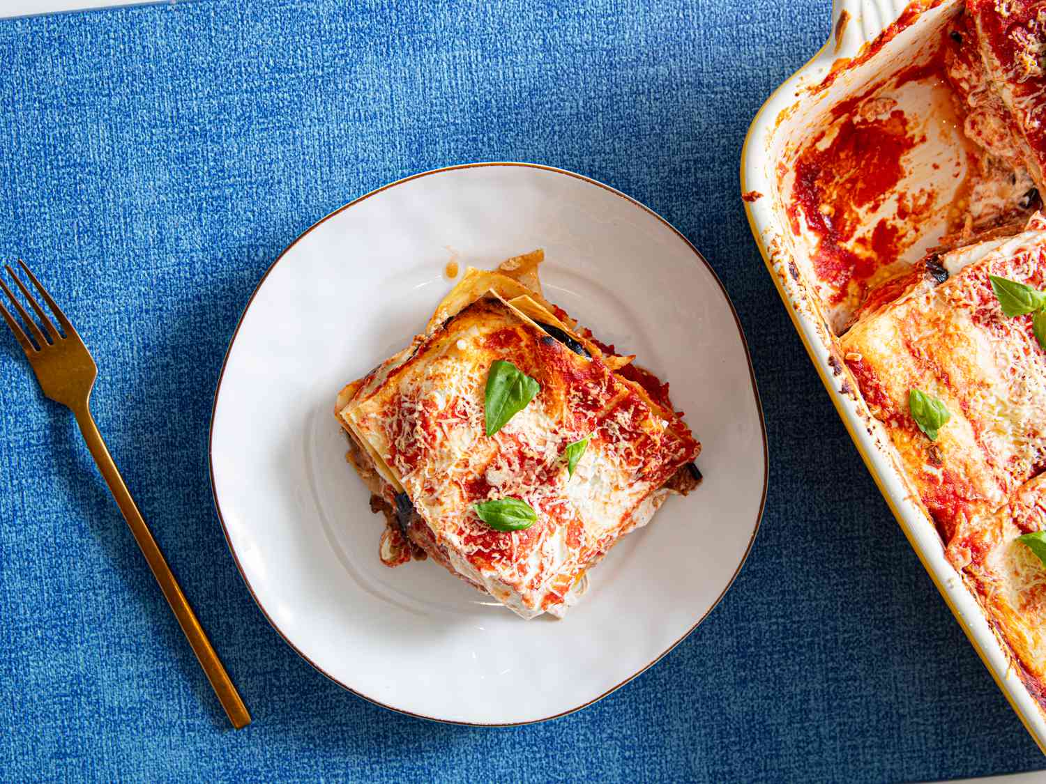 A slice of lasagna alla norma served on a white plate