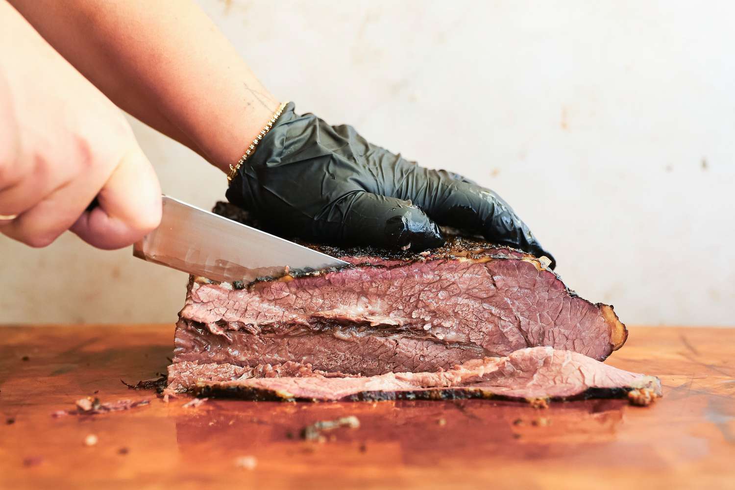 A person slicing meat using the Wusthof Classic Carving Knife