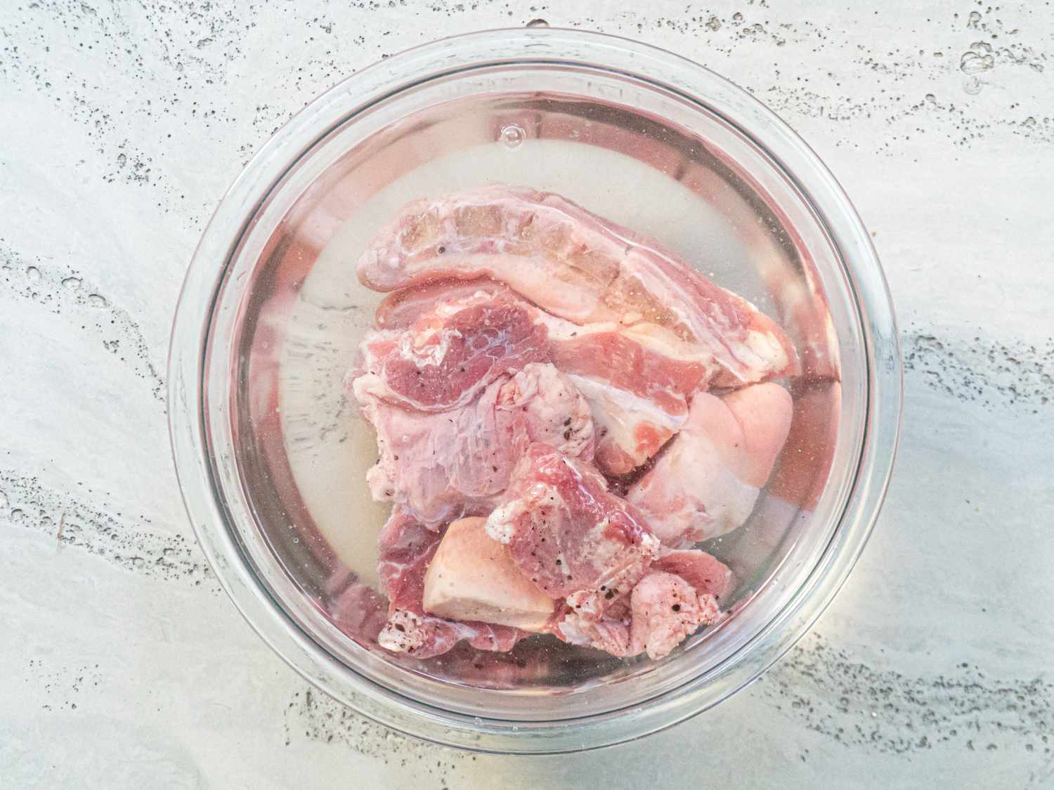 Overhead view of meat soaking in a bowl