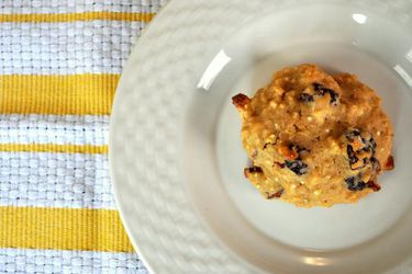 Overhead view of an almond cherry quinoa cookie, served on a white plate.