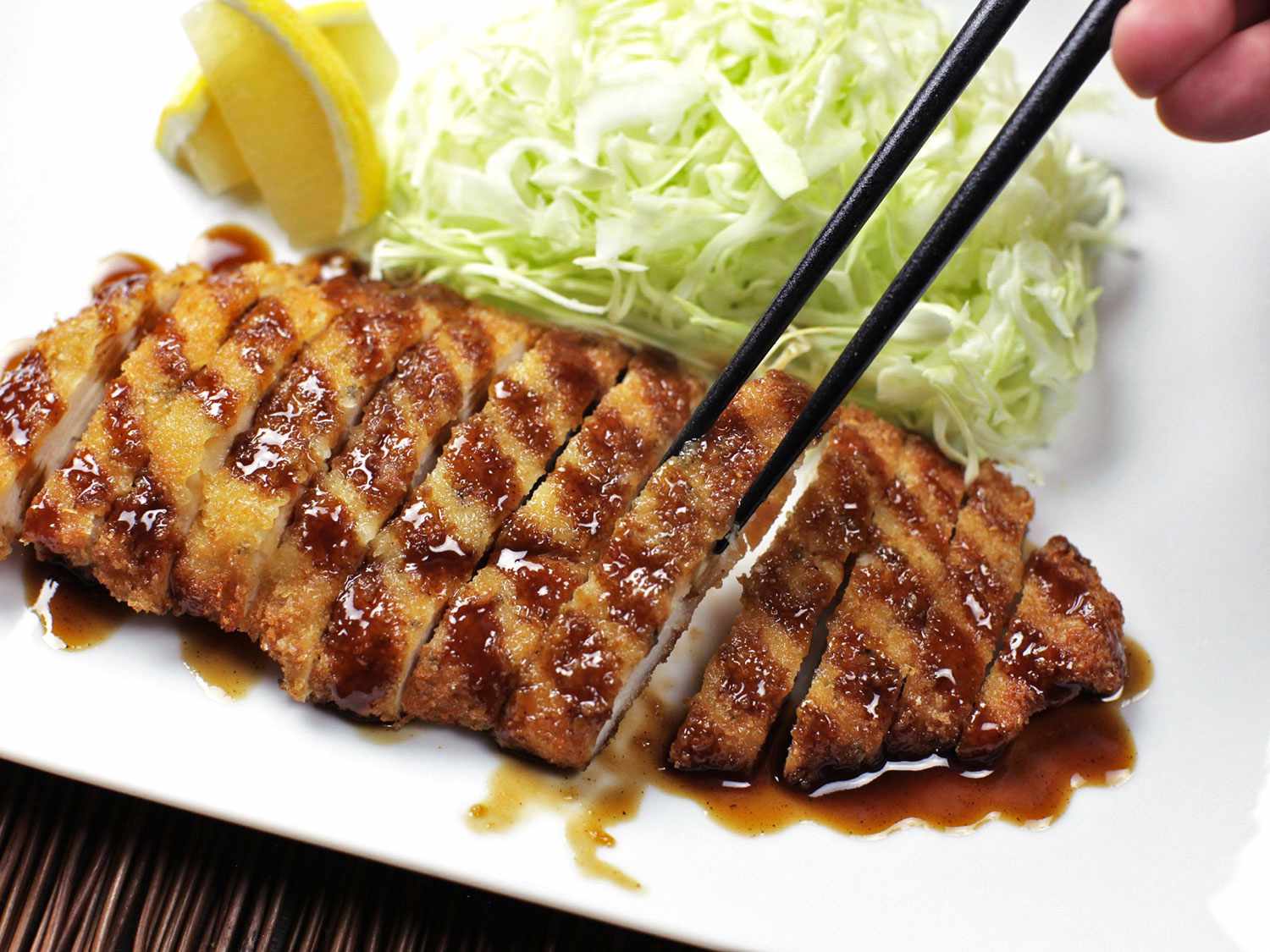 Sliced chicken katsu being picked up by chopsticks