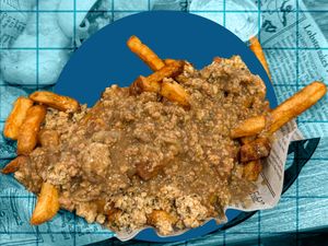 A plate of fries topped with minced meat and a sauce on a background resembling a blue grid and newspaper