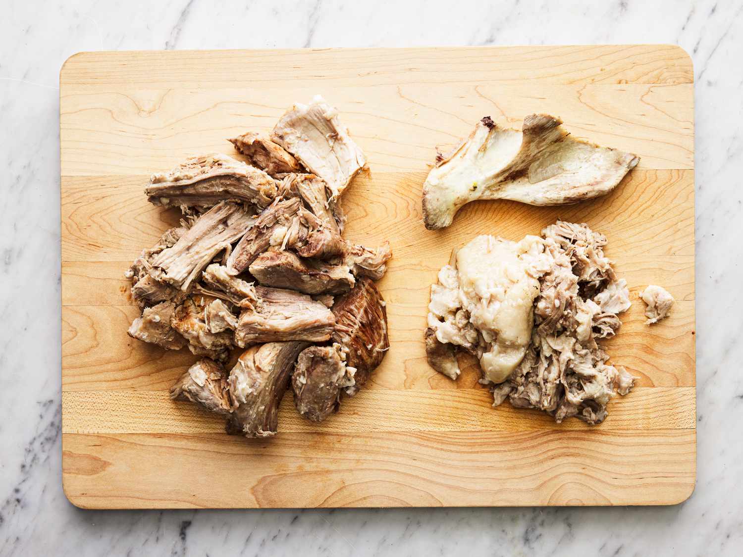 Overhead view of pork cut up on a cutting board