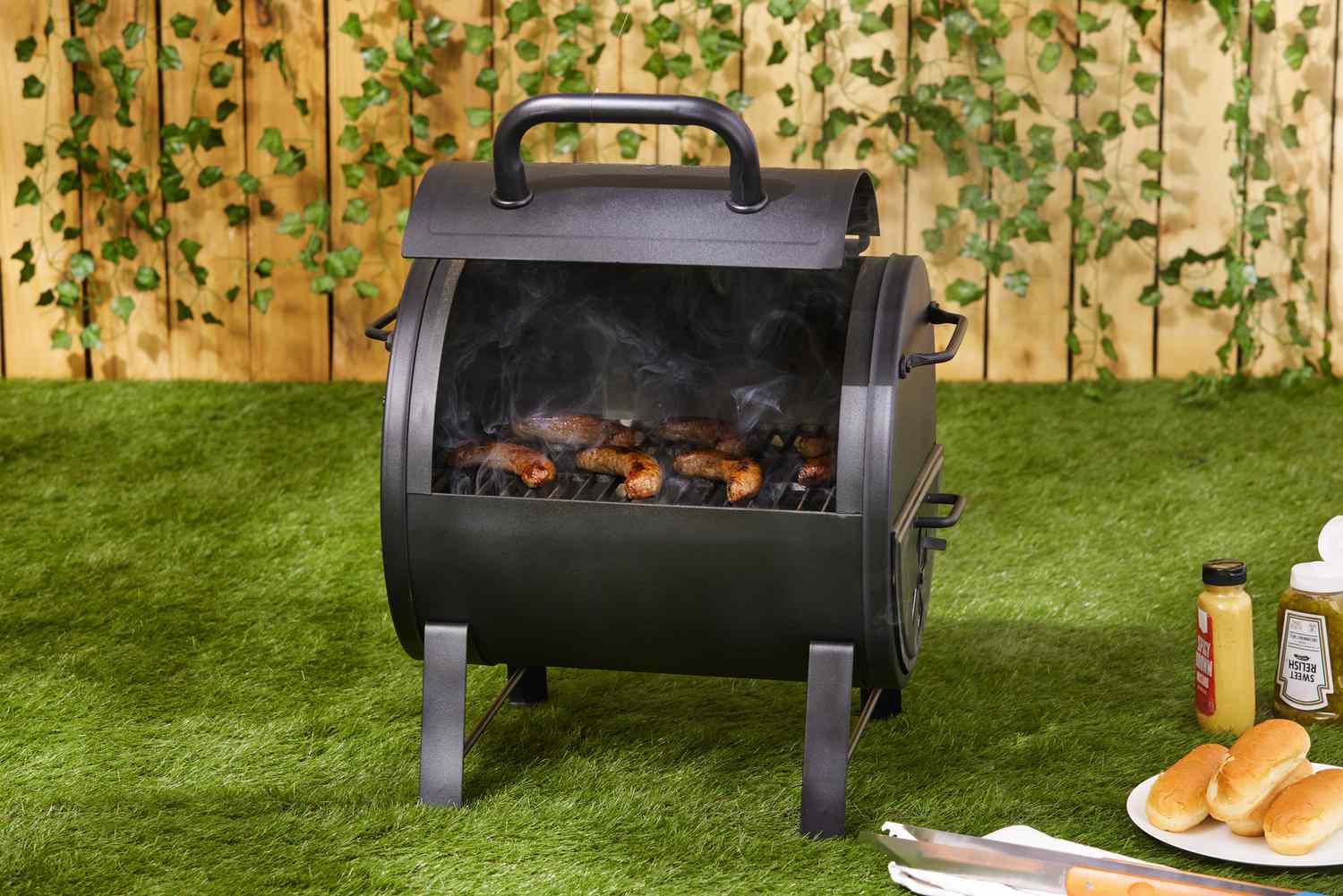 The Char-Griller portable charcoal grill cooking hot dogs.