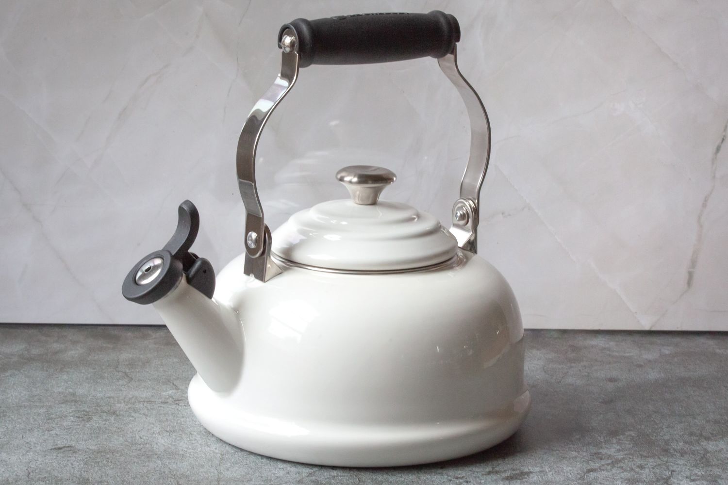 A kettle with a handle and spout on a countertop