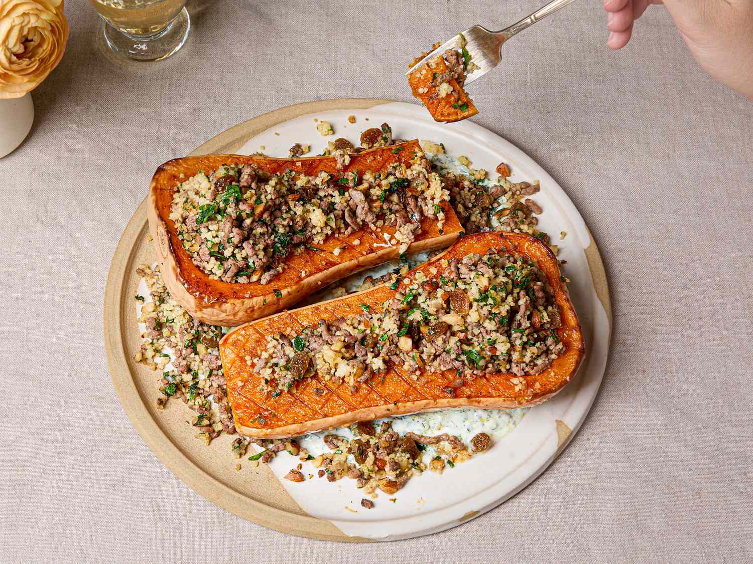 Butternut squash halves stuffed with couscous herbs and spiced mixture presented on a plate