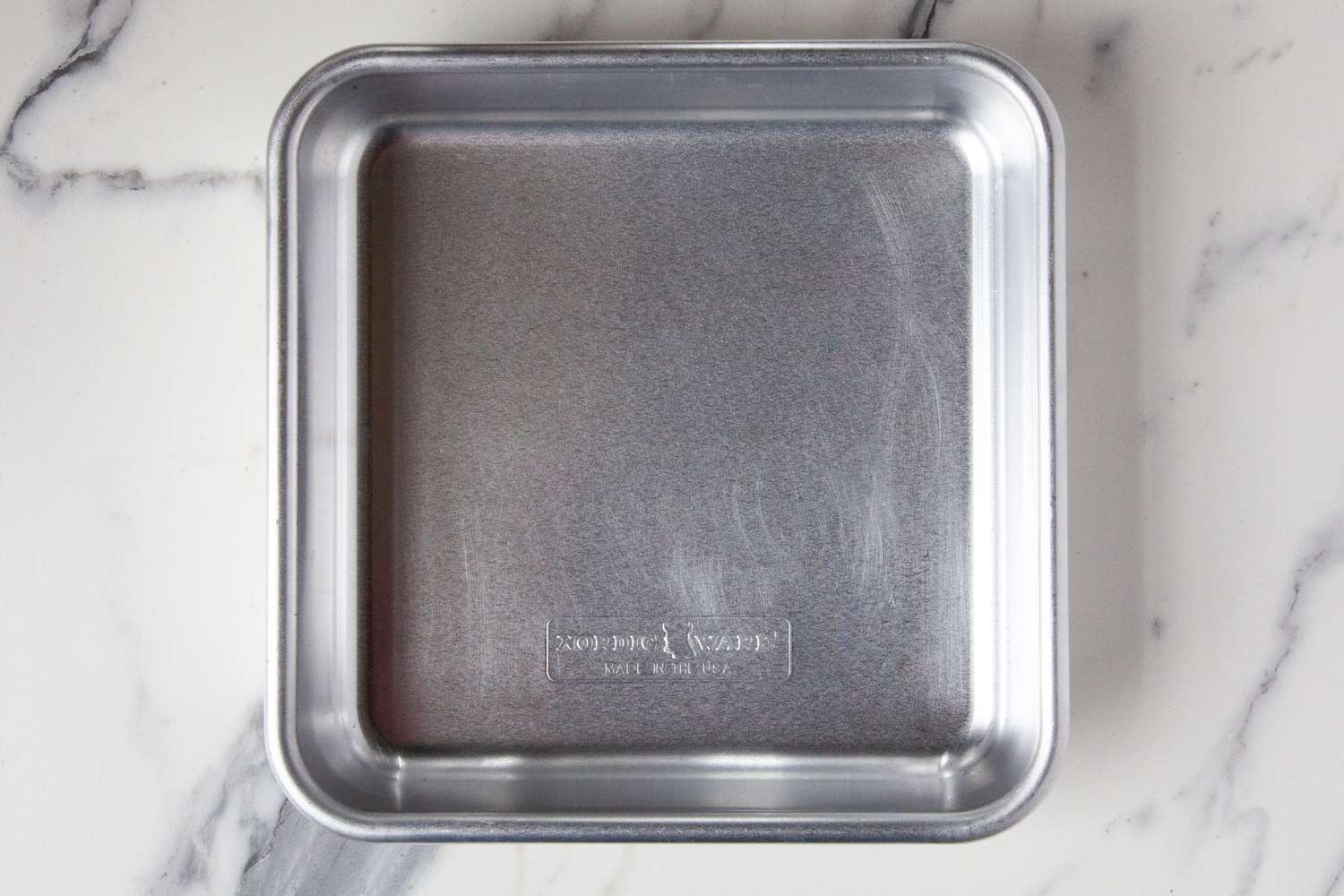 The Nordic Ware baking pan on a marble countertop.