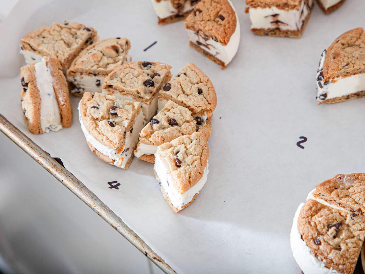 Cookies filled with ice cream arranged on a tray, cut into portions