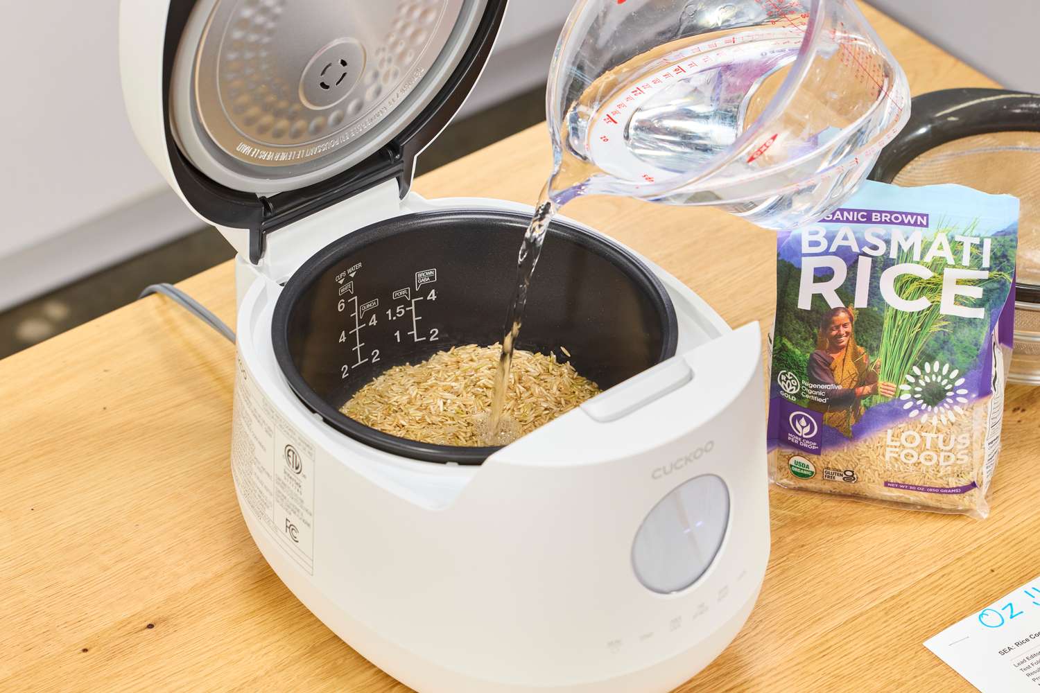 A person pours water into the Cuckoo 6-Cup Micom Rice Cooker