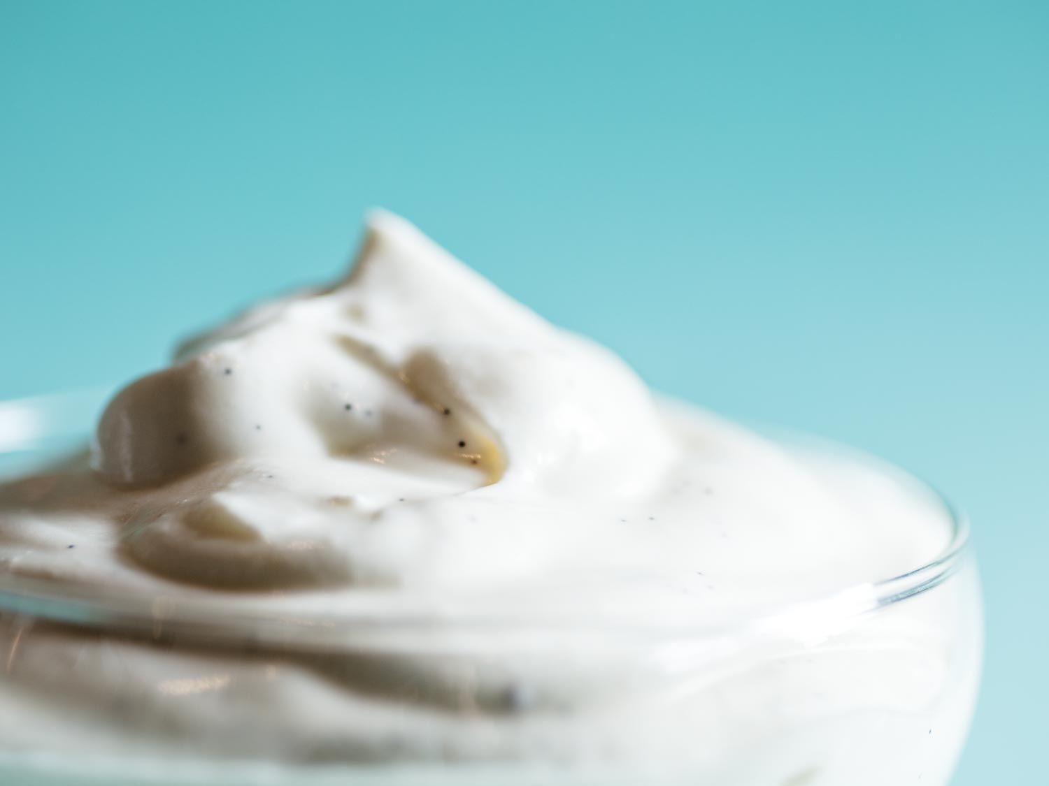 Whipped Greek yogurt dolloped into a glass dish.