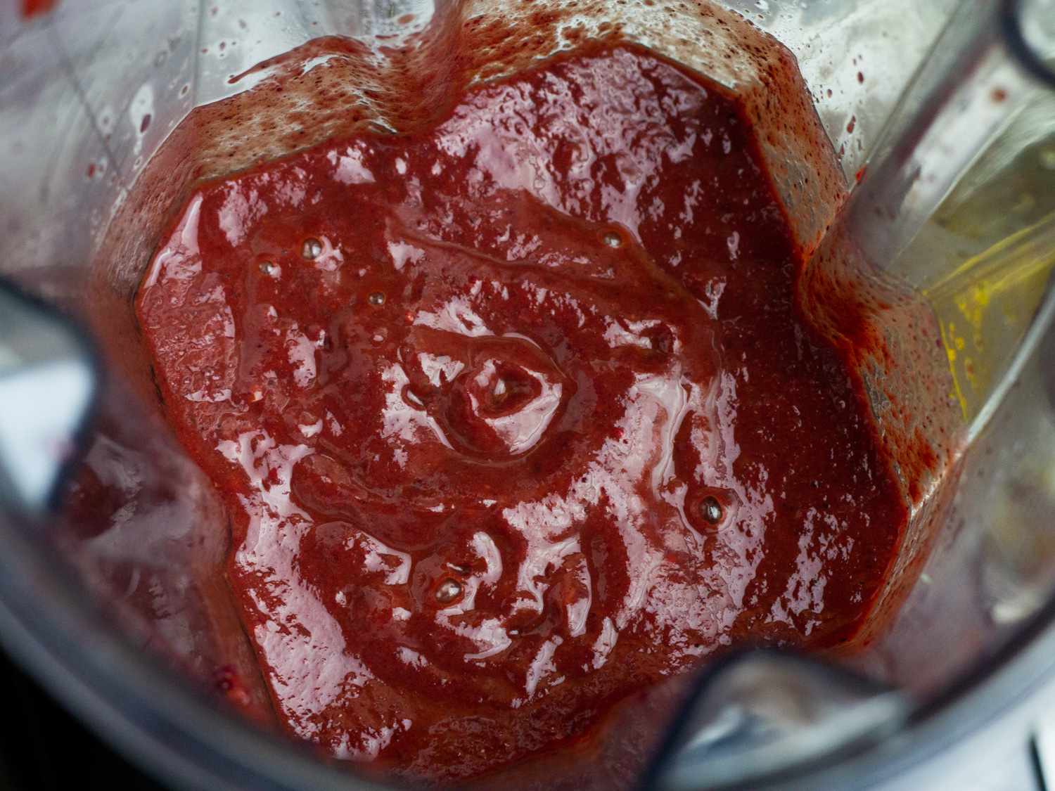 Closeup of the blended sauce in the carafe of a blender.