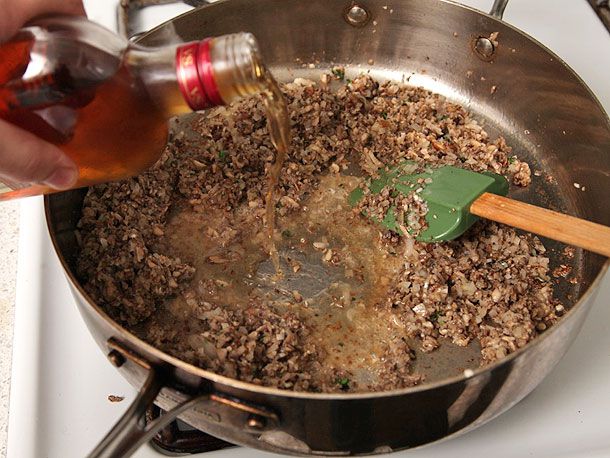 Adding Cognac to saute pan with minced mushrooms to make duxelles for beef Wellington.