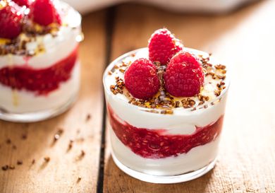 A glass of cranachan topped with fresh raspberries.