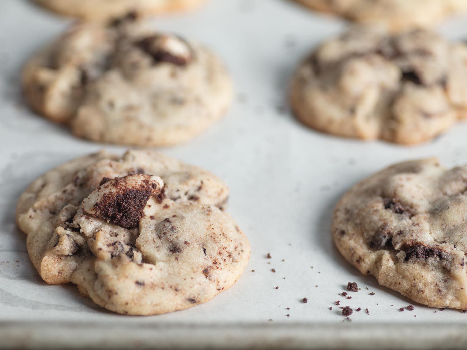Closeup of cookies 'n' cream cookies on a parchment-lined baking sheet.