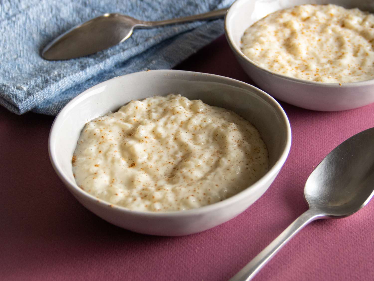a side close up of rice pudding with cinnamon in two bowls