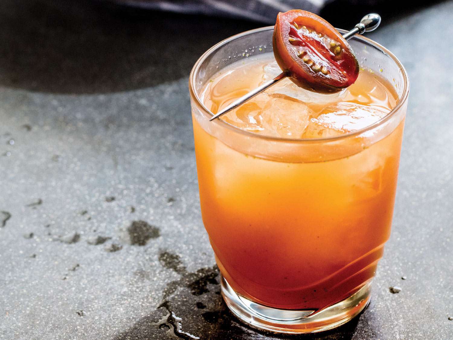 El Gallito (Pineapple-Chipotle Pitcher Cocktail) in rocks glass over ice garnished with skewered cherry tomato