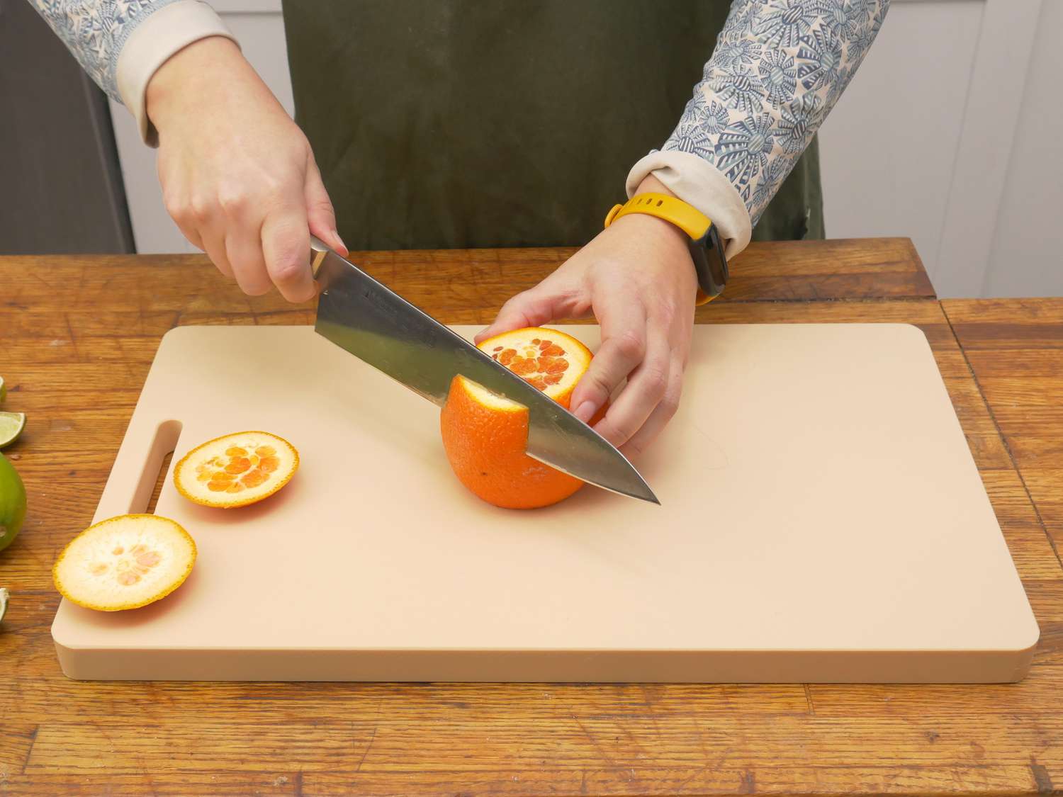 a person cutting the peel off of an orange on the yoshihiro cutting board