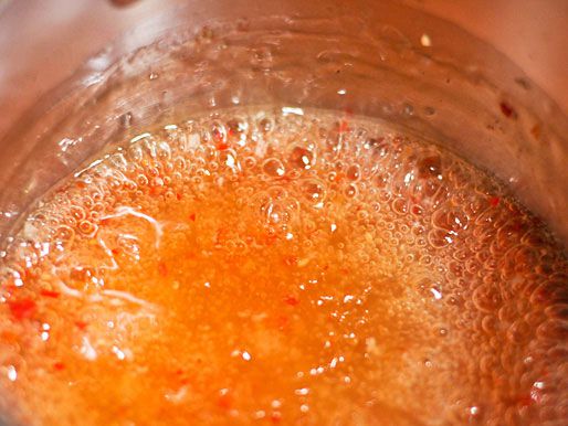 Cornstarch slurry is added to the simmering chili sauce for body. 