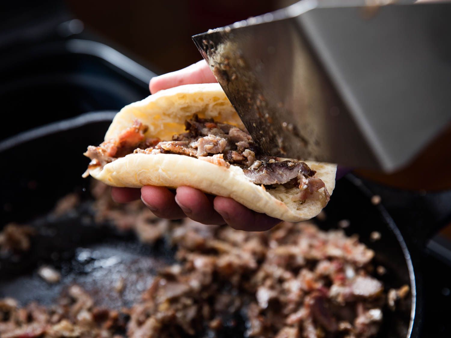The pan-fried filling is transferred to warmed, split pan árabe (pita bread).