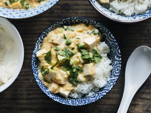 Overhead view of slippery eggs with tofu and peas in a blue patterned bowl