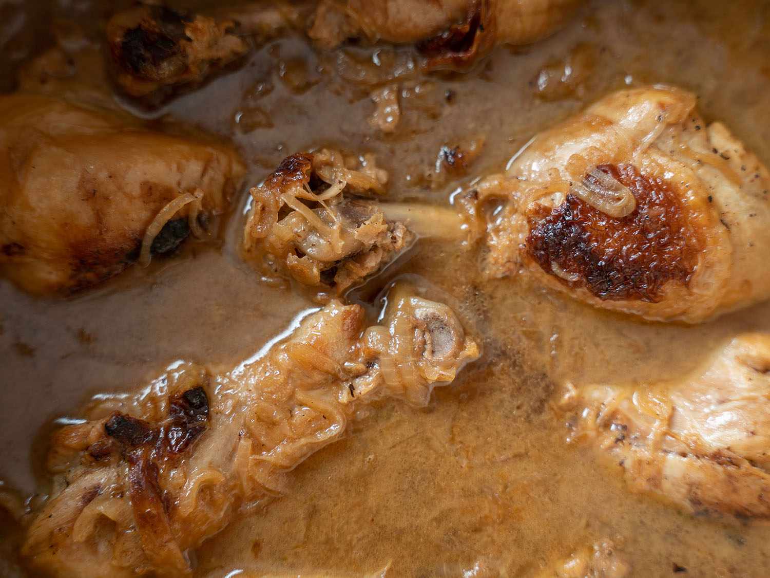 Falling-off-the-bone chicken simmering in liquid.