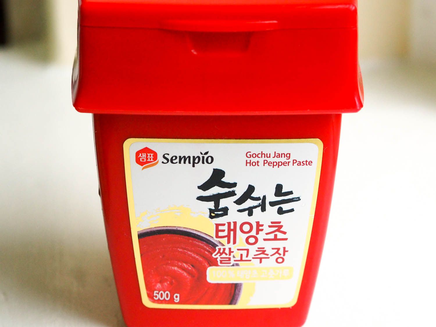 Close-up of a tub of gochujang (Korean chile paste).