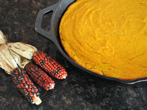 Pumpkin cornbread baked in a cast-iron skillet.