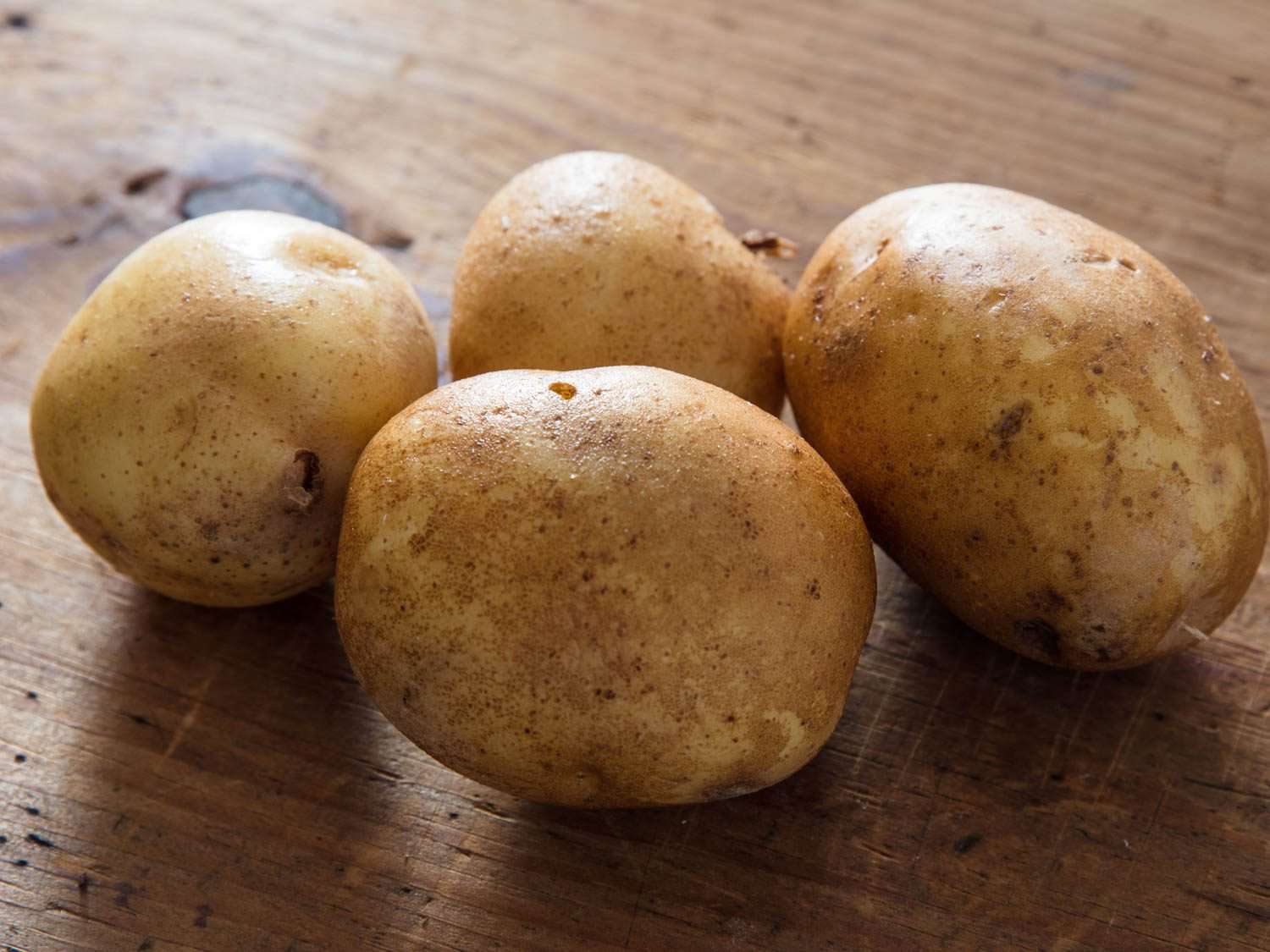Yukon gold potatoes on a cutting board.