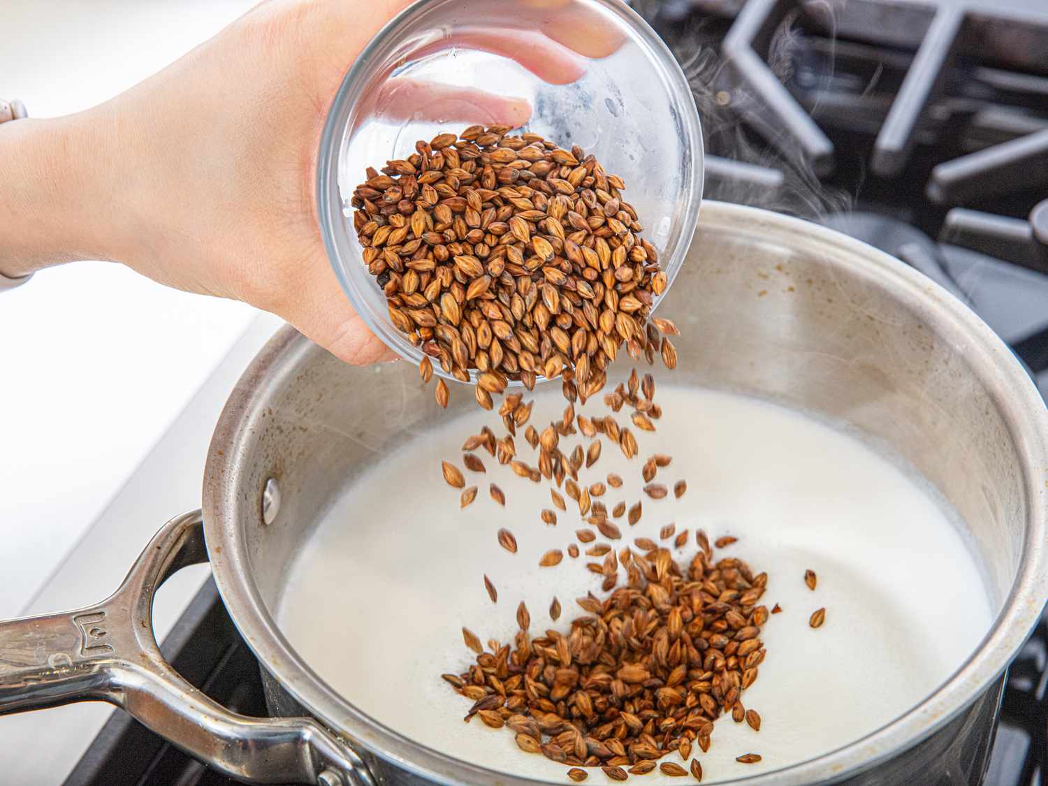Boricha tea being poured into a pot on a stovetop