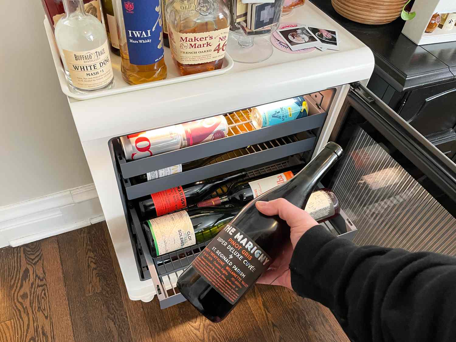A person removing a bottle of wine from the Rocco Super Smart Wine Fridge