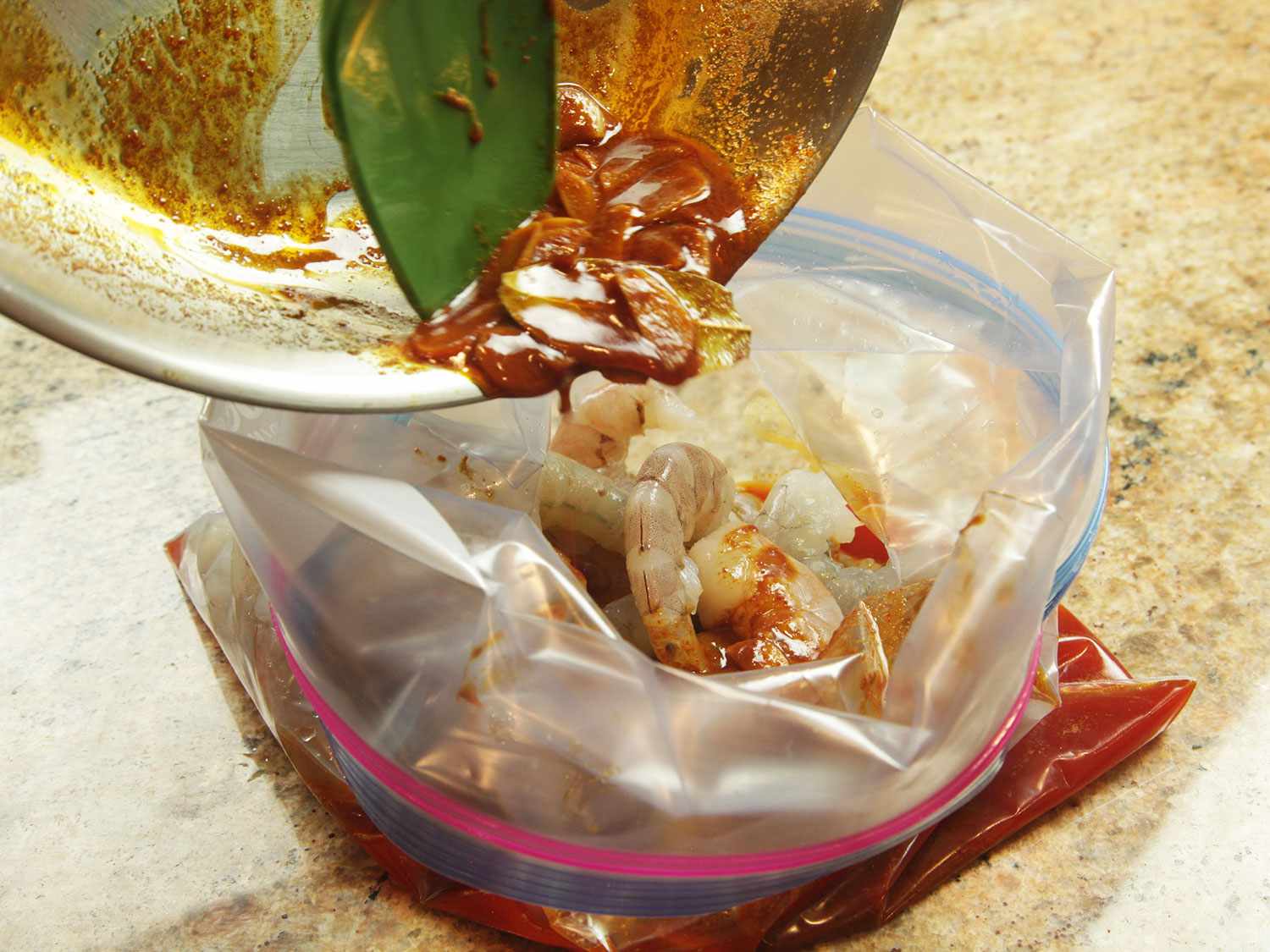 The oil-garlic-paprika-butter mixture is added to a bag with the shrimp.