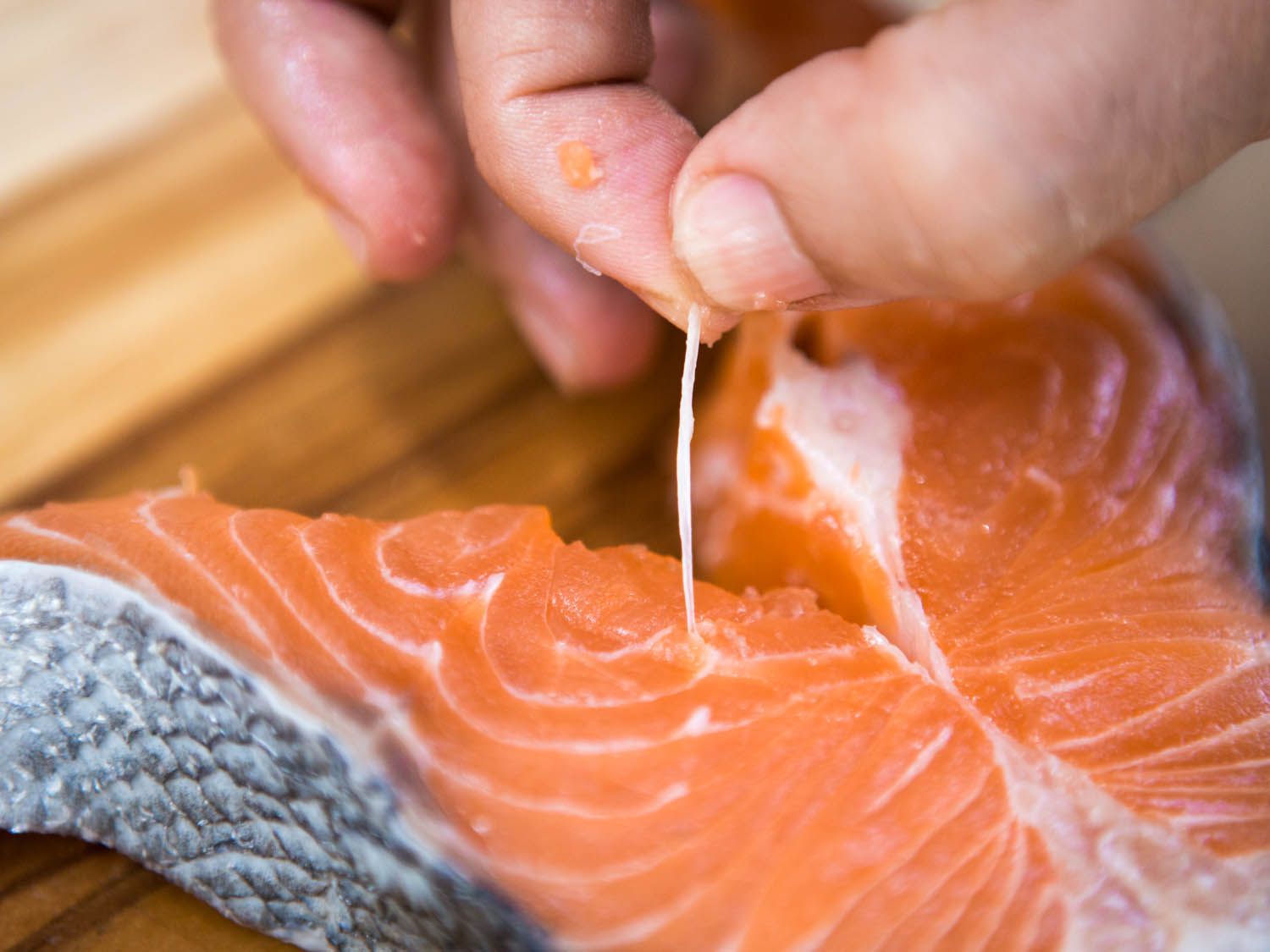 Removing the bones from a salmon steak with fingertips.