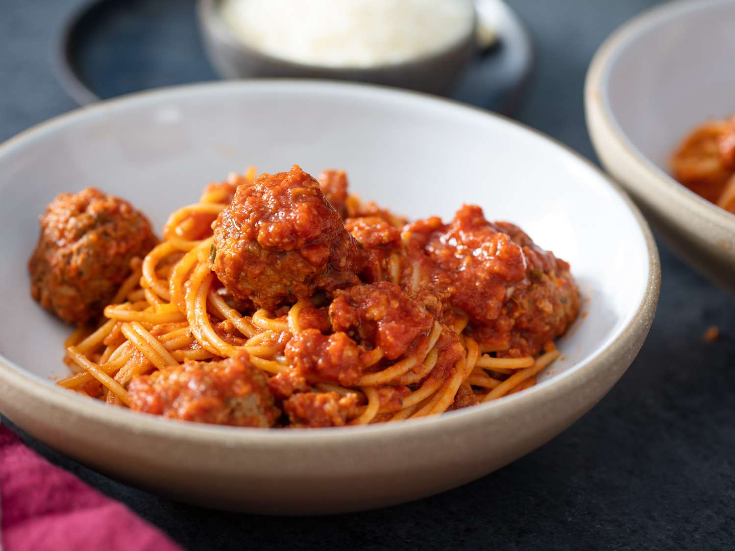 side angle of spaghetti and meatballs in a white bowl