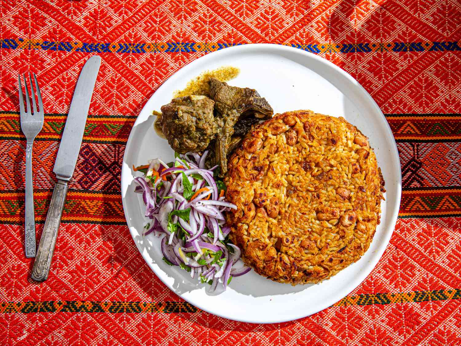 Overhead view of finished tacu tacu on a traditional Peruvian fabric