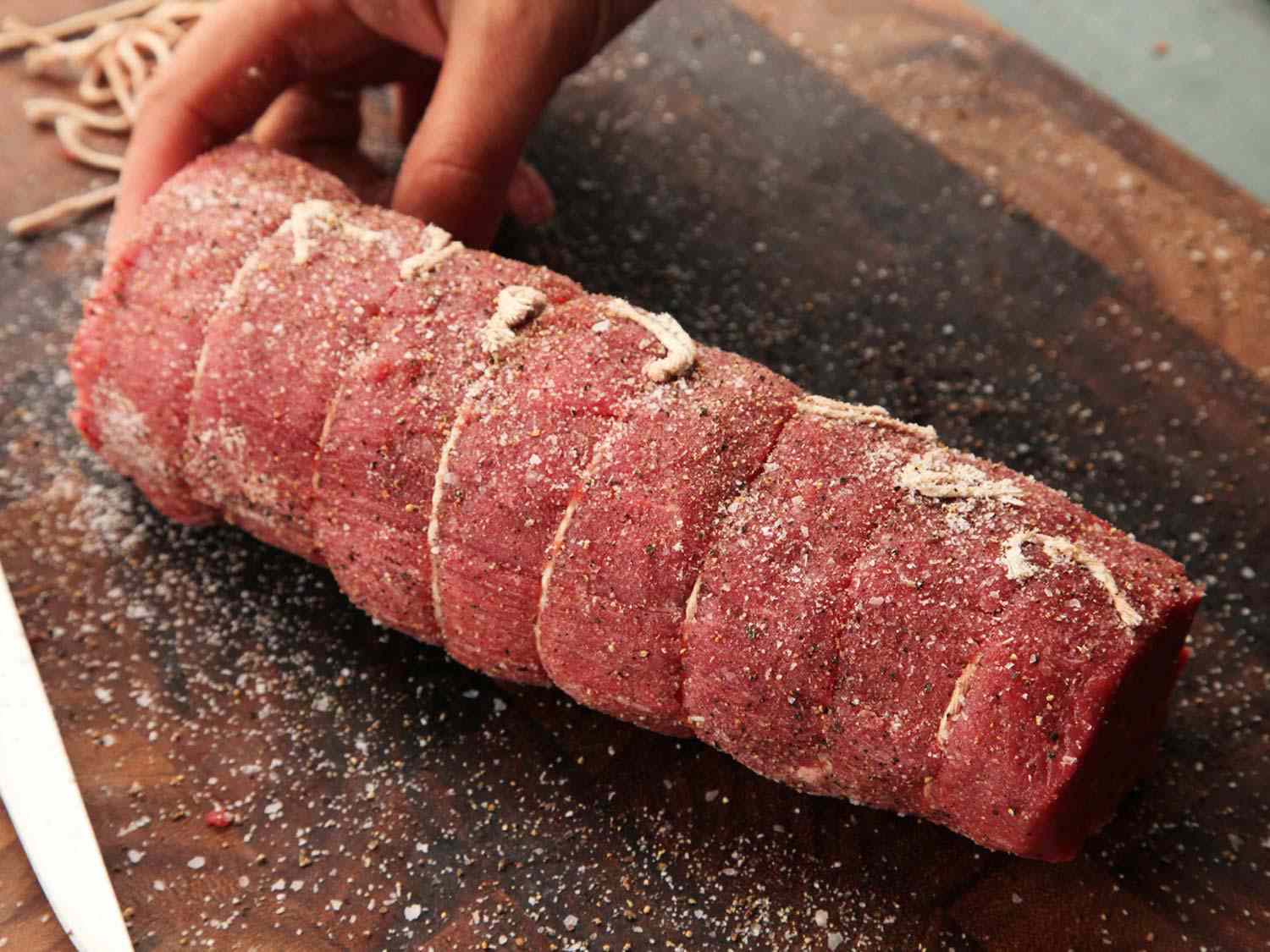 Tied beef tenderloin roast seasoned with salt and pepper