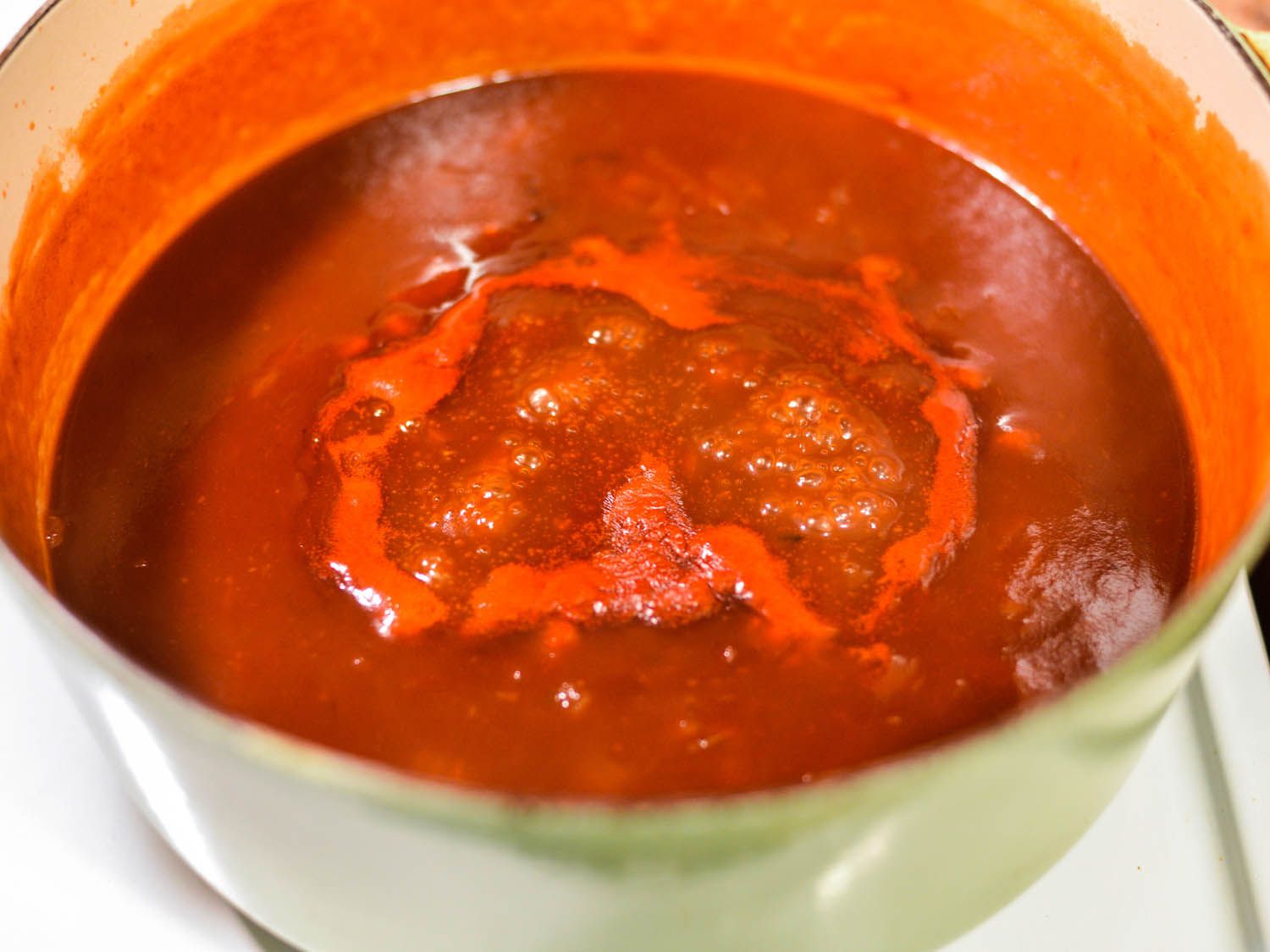 Closeup of the sauce bubbling away in a saucepan.