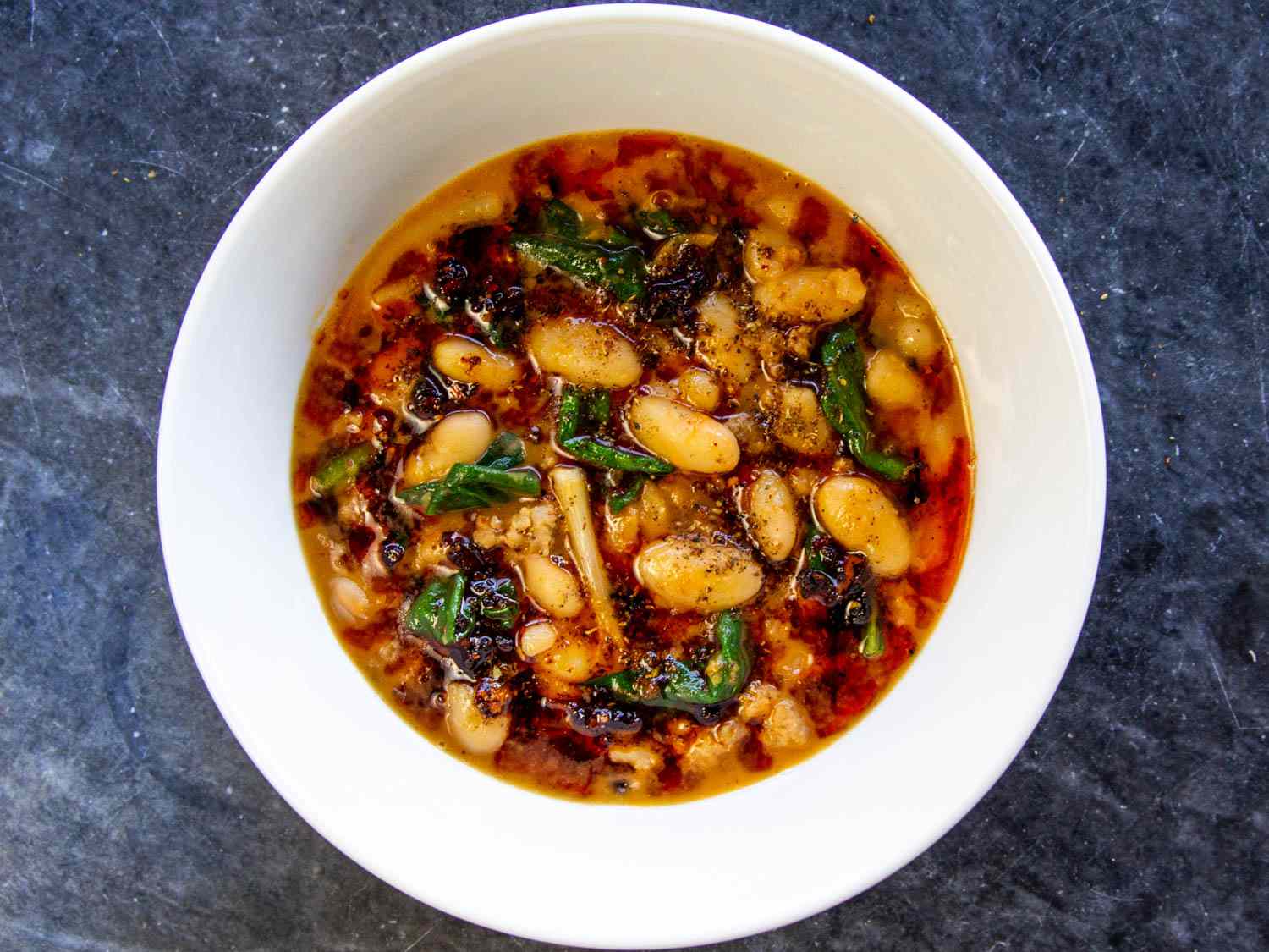 Overhead view of mapo beans, served in a white bowl.