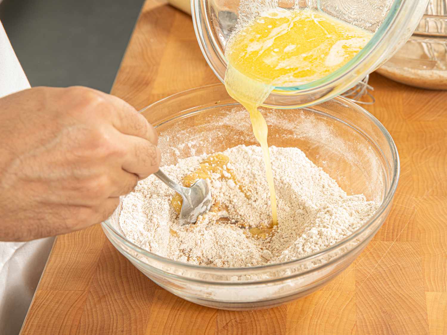 Side view of adding butter mixture to dry ingredients