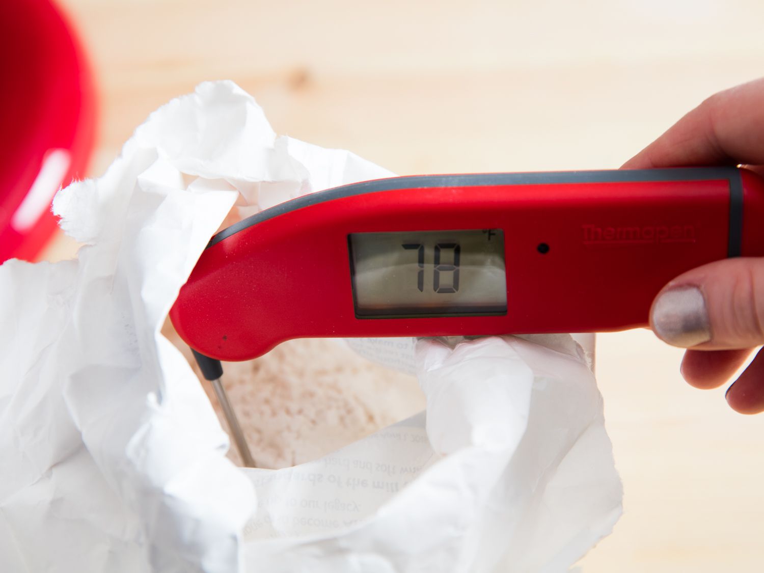 A thermometer in an open bag of flour, registering 78 degrees Fahrenheit