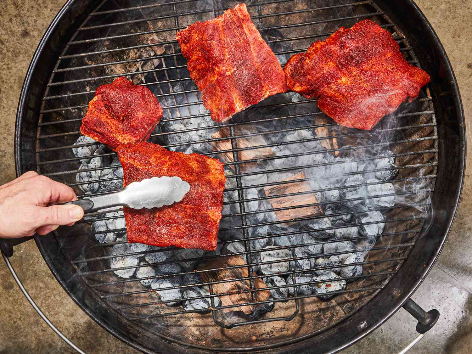 Overhead view of ribs on a charcoal grill.