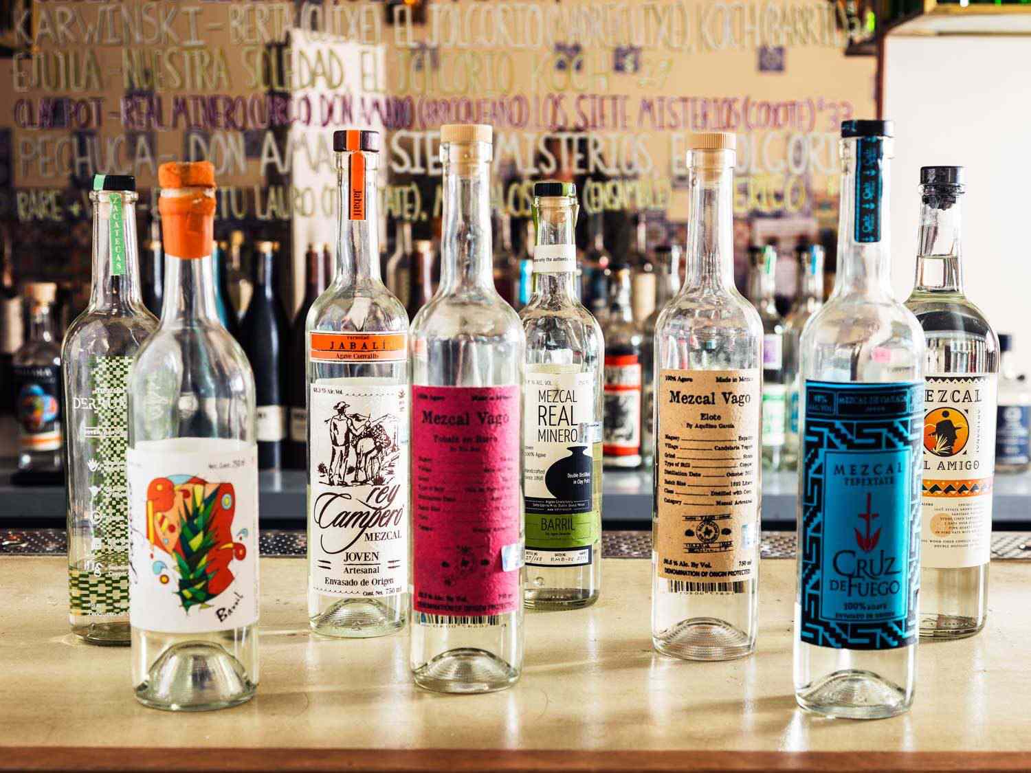 A selection of mezcals in bottles on a bar counter at Madre Mezcaleria.
