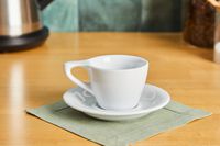 A white coffee mug on a saucer.