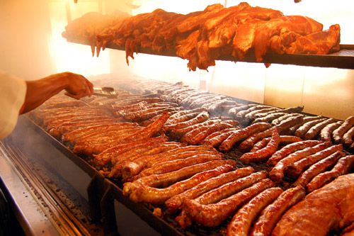 A cooking rack full of barbecue and links. 