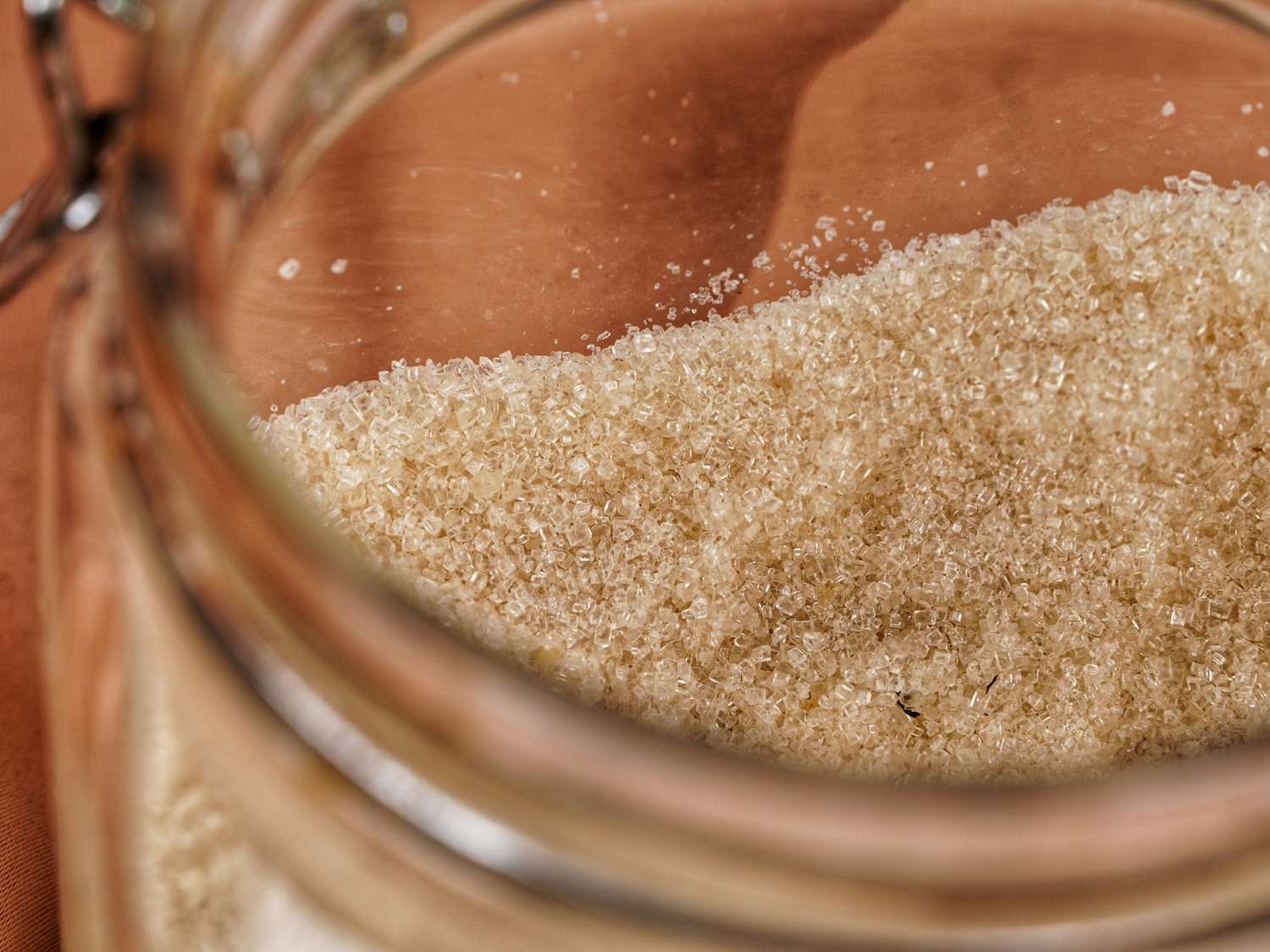 Coarse granulated sugar in a glass jar seen closeup