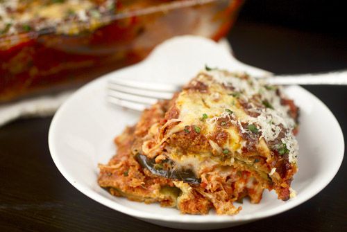 A portion of the finished eggplant parmesan, dusted with grated parmesan and chopped parsley.