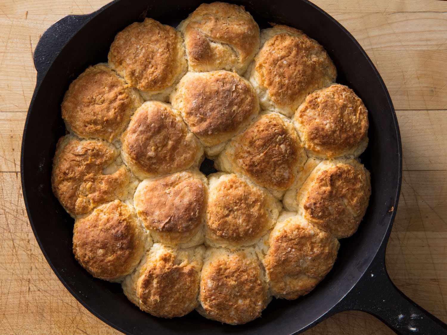 Overhead shot of golden brown yogurt biscuits in a cast-iron skillet.